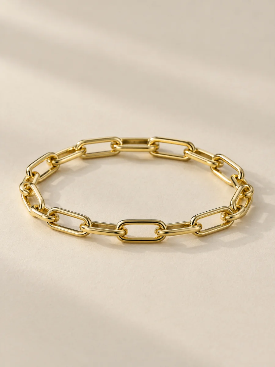 Pulseira dourada de elos retangulares em fundo bege