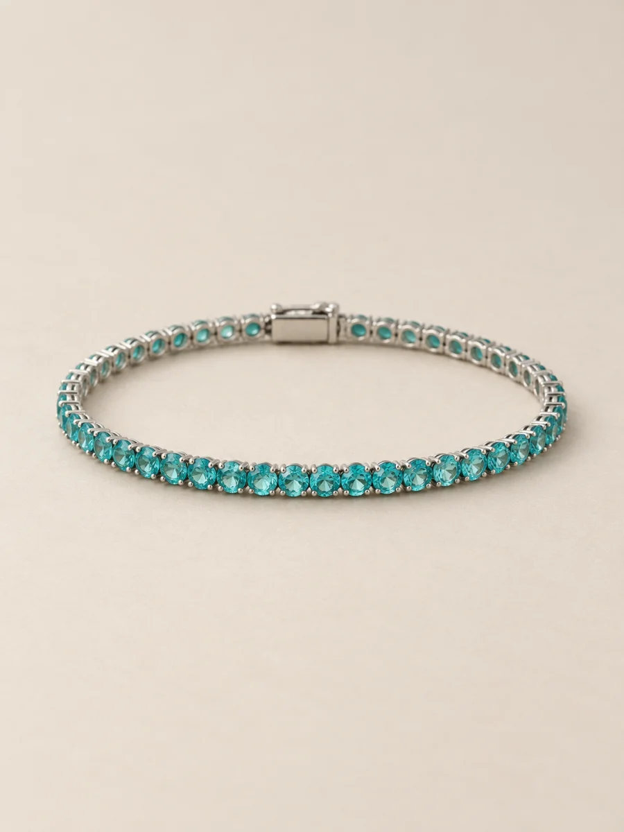Pulseira riviera em ouro branco com pedras turquesa em fundo bege