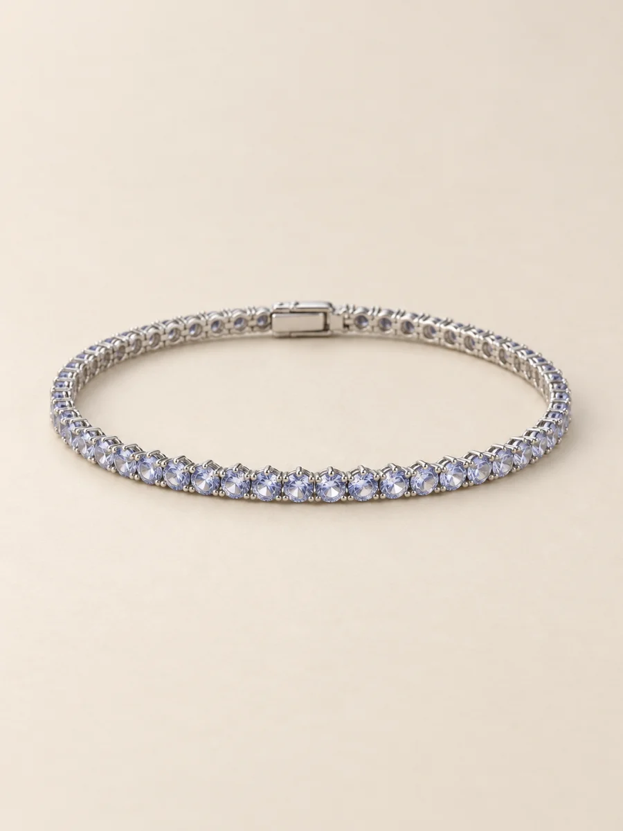 Pulseira riviera em ouro branco com pedras claras em fundo bege