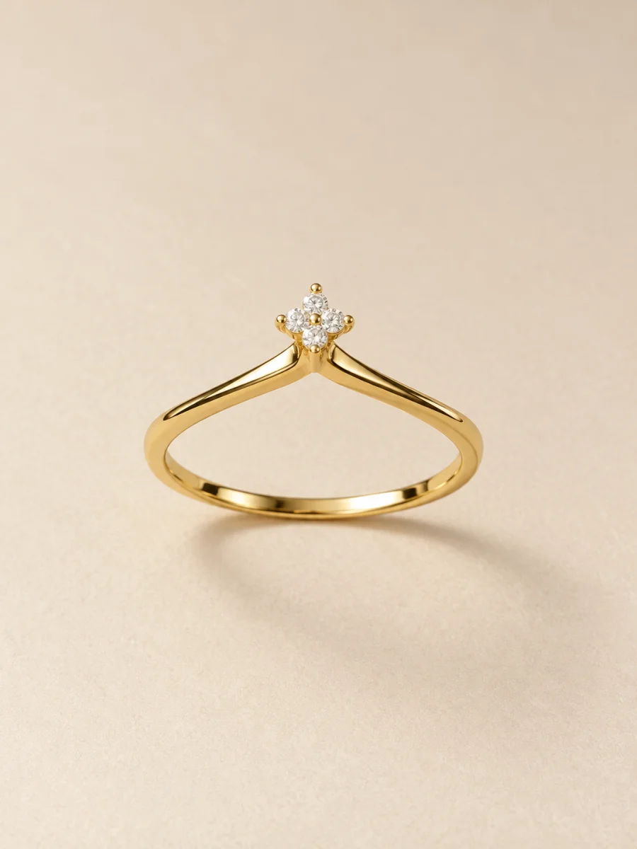 Anel dourado com pequena flor de pedras claras em fundo bege