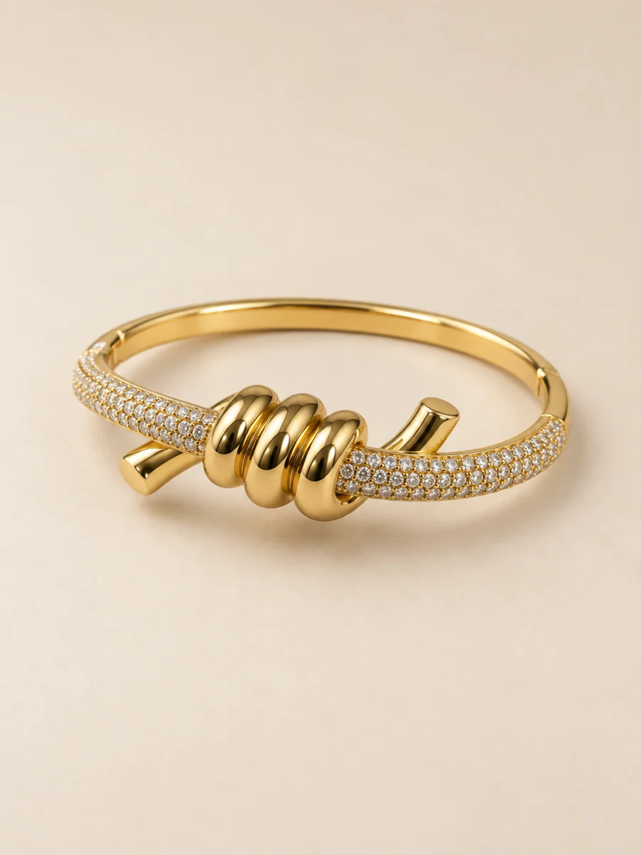 Pulseira banhada a ouro 18k com nó e pedras claras em fundo bege