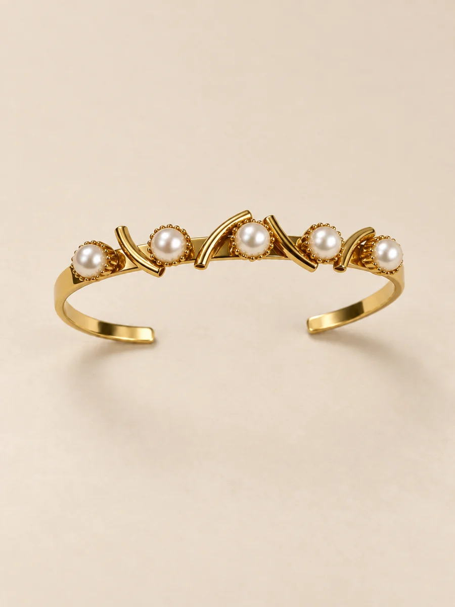 Pulseira banhada a ouro 18k rígida com pérolas em fundo bege