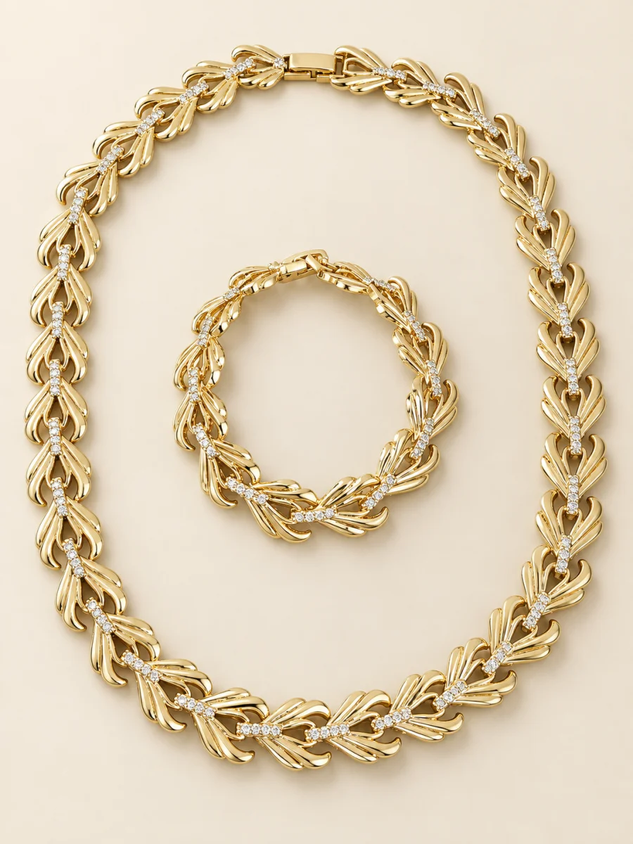 Conjunto dourado de folhas, colar e pulseira, em fundo bege