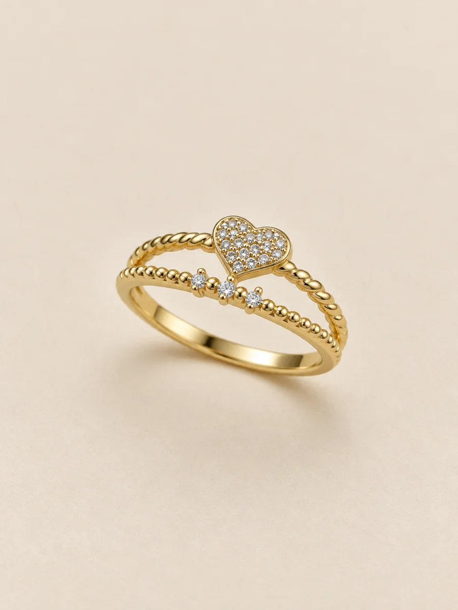 Anel dourado de três faixas com coração cravejado — fundo bege