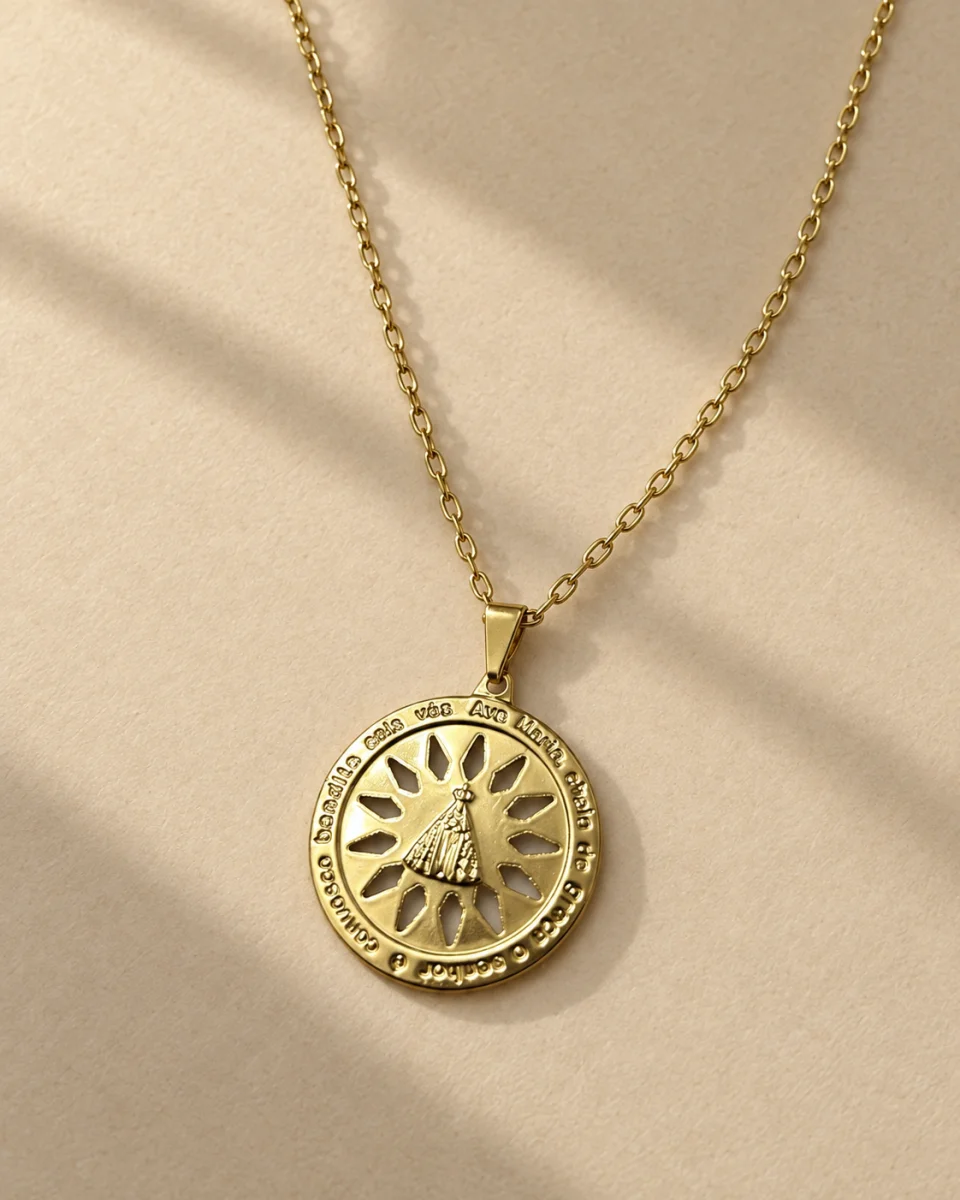 Colar com medalha de Nossa Senhora e oração gravada sobre fundo bege