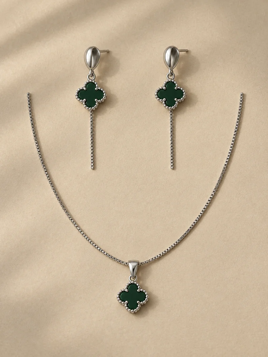 Conjunto prateado com trevos verdes em fundo bege
