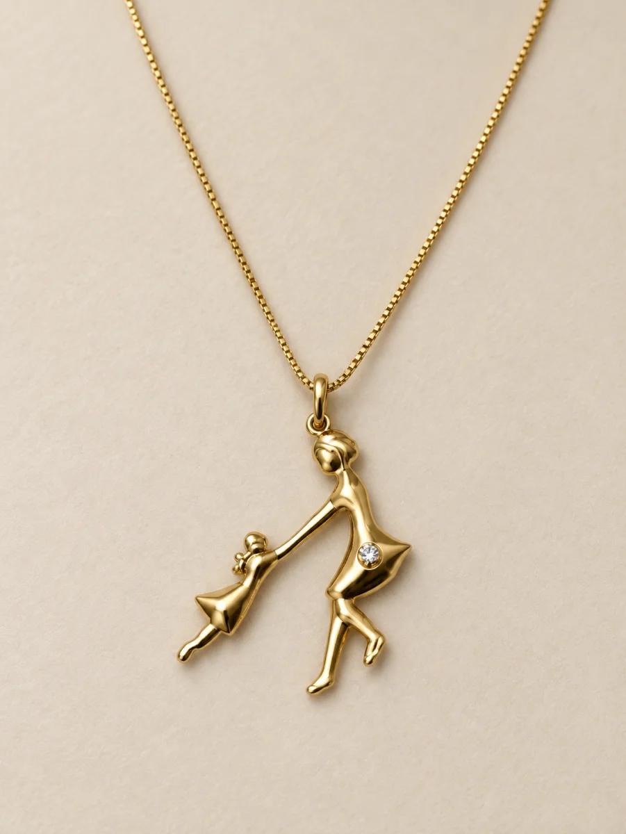 Colar dourado com silhueta de mãe e filha de mãos dadas sobre fundo bege
