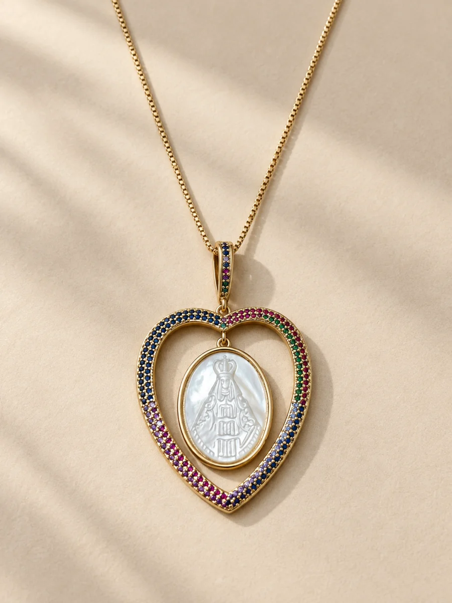 Colar com coração e medalha religiosa sobre fundo bege