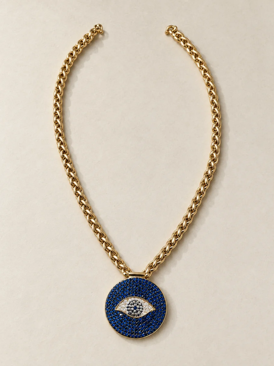 Colar dourado de olho grego azul sobre fundo bege