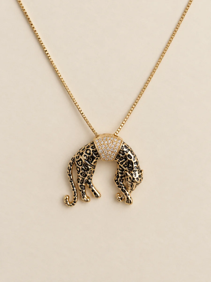Colar dourado com leopardo manchado de cabeça baixa sobre fundo bege