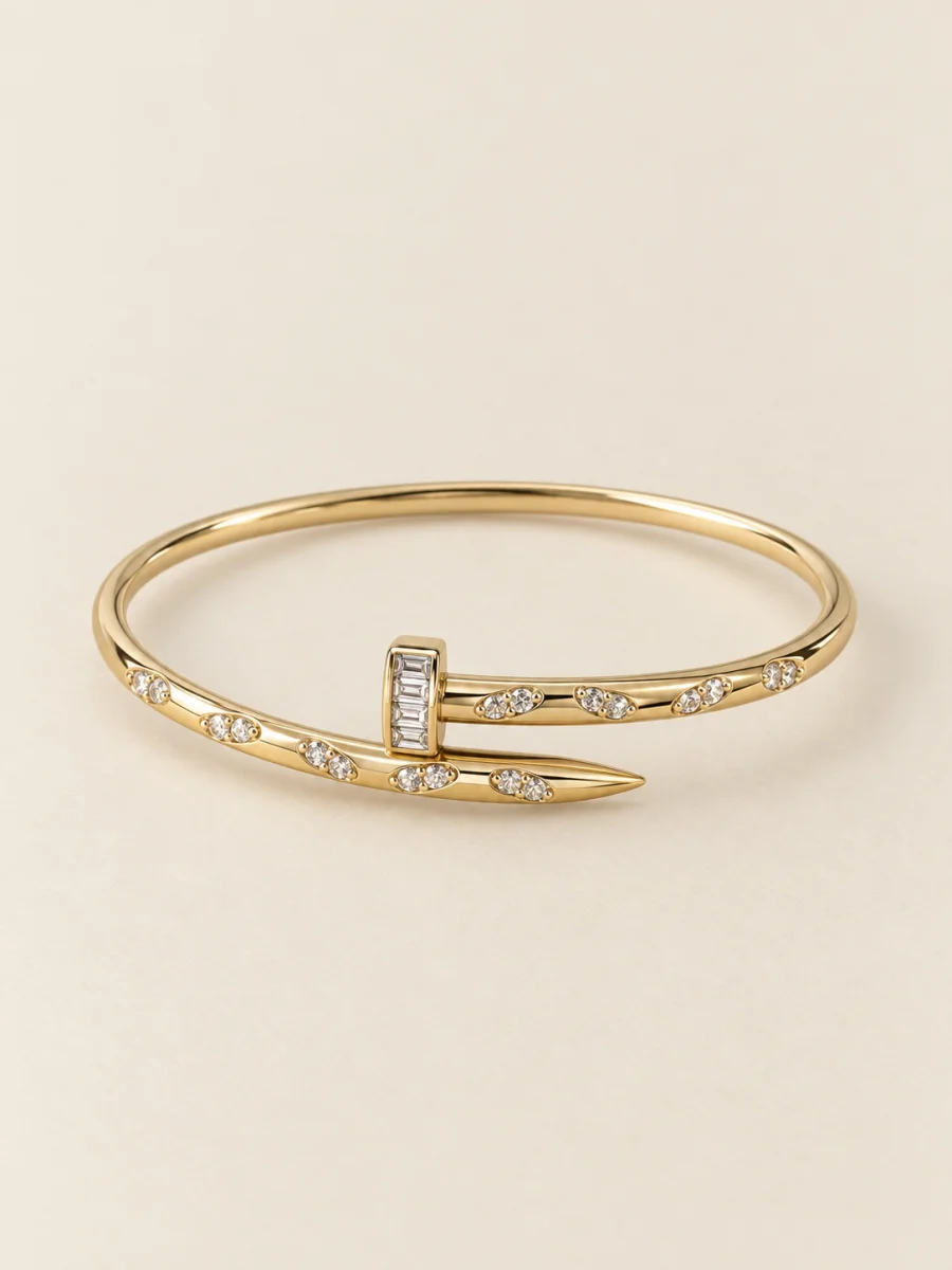 Bracelete dourado em forma de prego em fundo bege