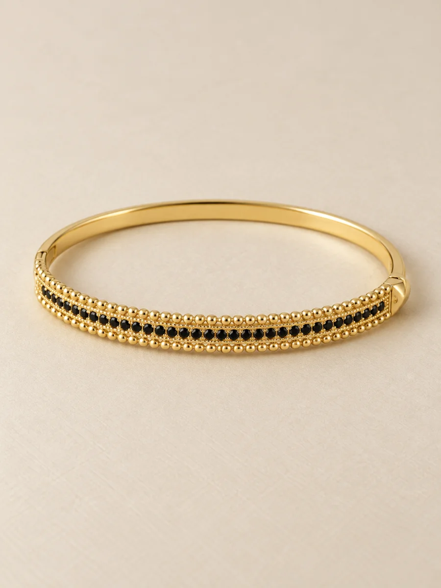 Bracelete com pedras pretas em fundo bege