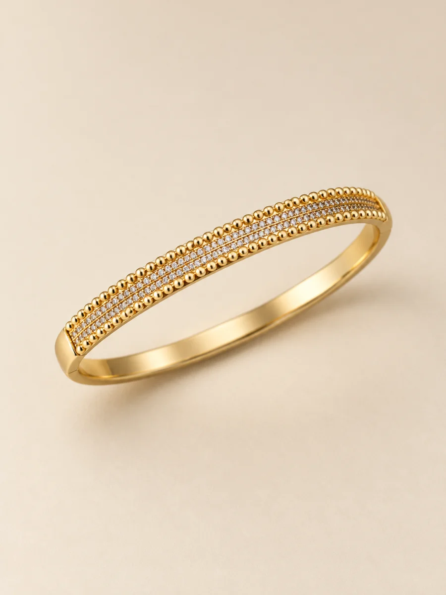 Bracelete dourado em fundo bege