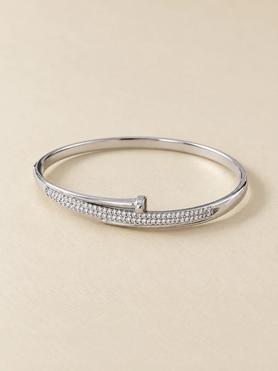 Pulseira prateada com faixa de pedras — foto em fundo bege