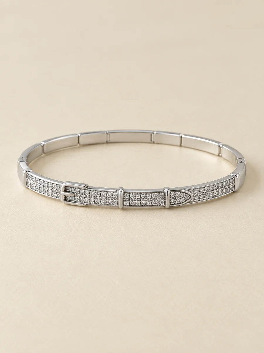 Pulseira prateada com pedras claras — foto em fundo bege