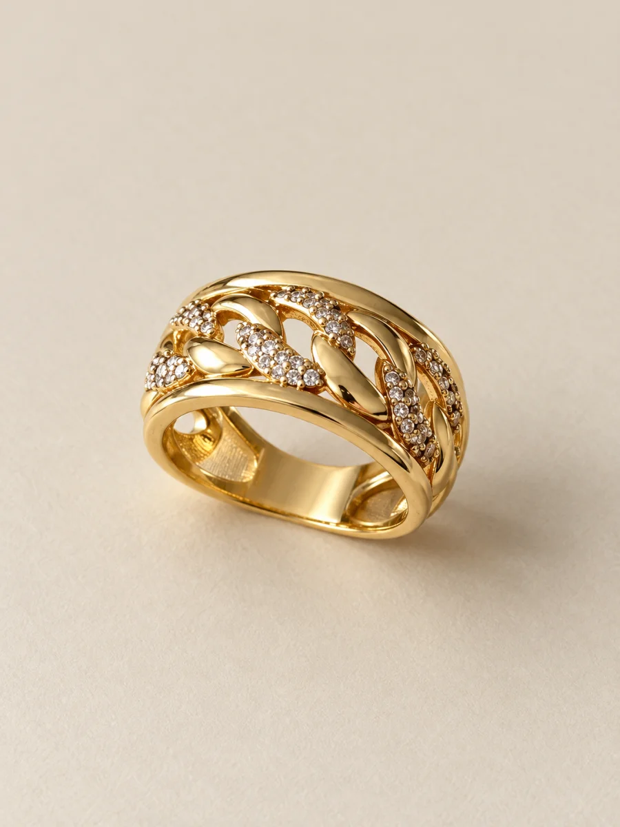 Anel banhado a ouro 18k com faixas onduladas e pedras claras em fundo bege