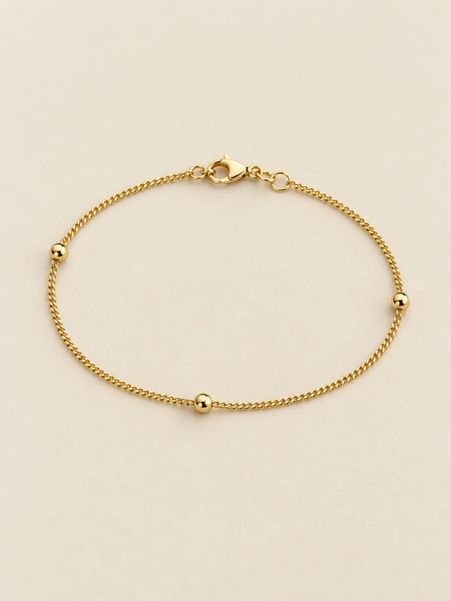 Pulseira fina com esferas — foto em fundo bege