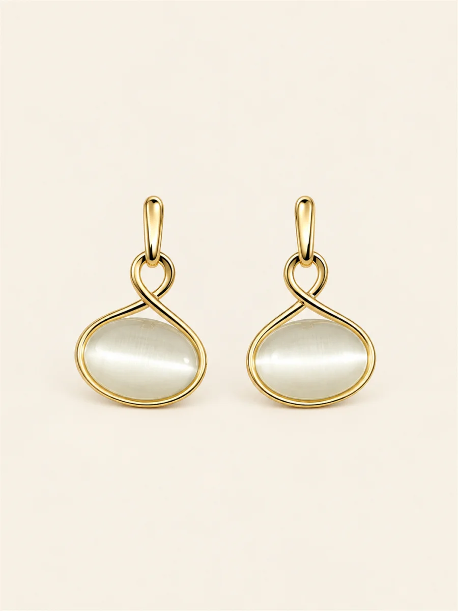 Par de brincos dourados com detalhe branco em fundo bege