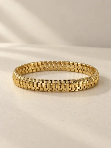 Pulseira dourada articulada com elos retangulares em fundo bege