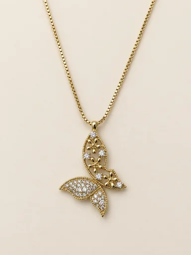 Colar dourado com pingente floral vazado e cauda cravejada sobre fundo bege