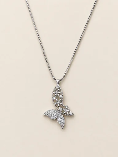 Colar prateado com pingente floral vazado e cauda cravejada sobre fundo bege