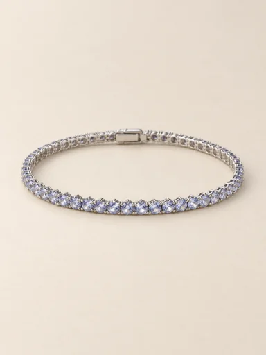Pulseira riviera em ouro branco com pedras claras em fundo bege