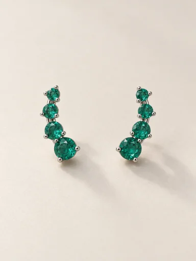 Brincos de ouro branco com quatro pedras verdes sobre fundo bege