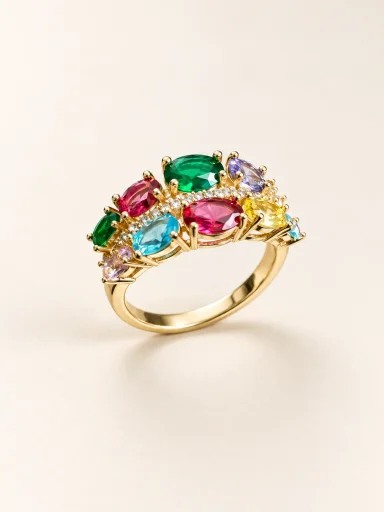 Anel dourado com pedras coloridas sobre fundo bege