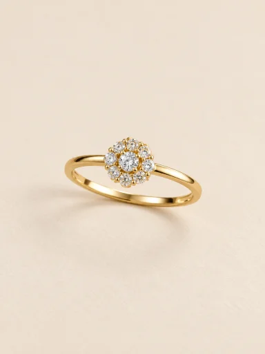 Anel dourado floral com pedras claras sobre fundo bege