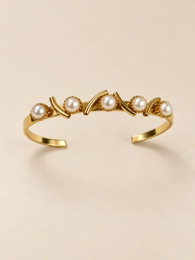 Pulseira banhada a ouro 18k rígida com pérolas em fundo bege