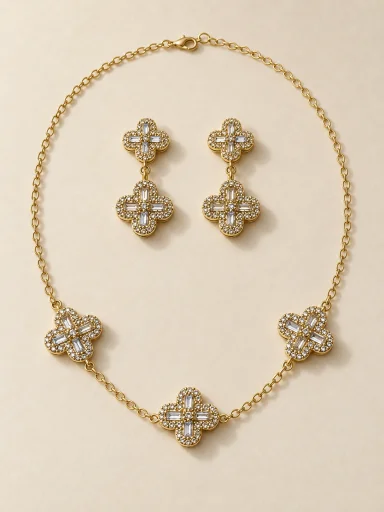 Conjunto dourado de flores com pedras claras em fundo bege