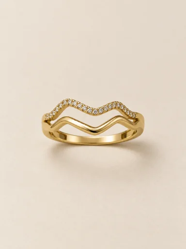Anel dourado de duas ondas com pedras claras — fundo bege