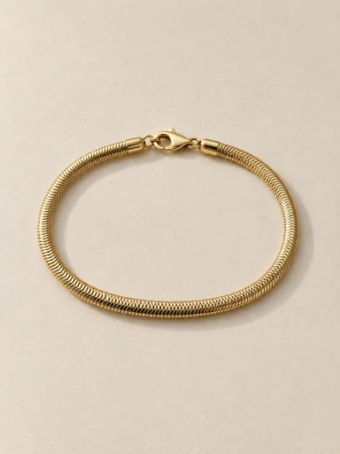 Pulseira malha cobra dourada em fundo bege, padrão 3:4
