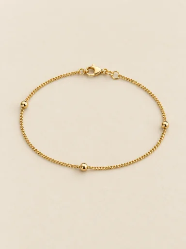 Pulseira fina com esferas — foto em fundo bege