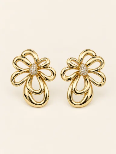 Brinco floral dourado vazado com centro cravejado em fundo bege.